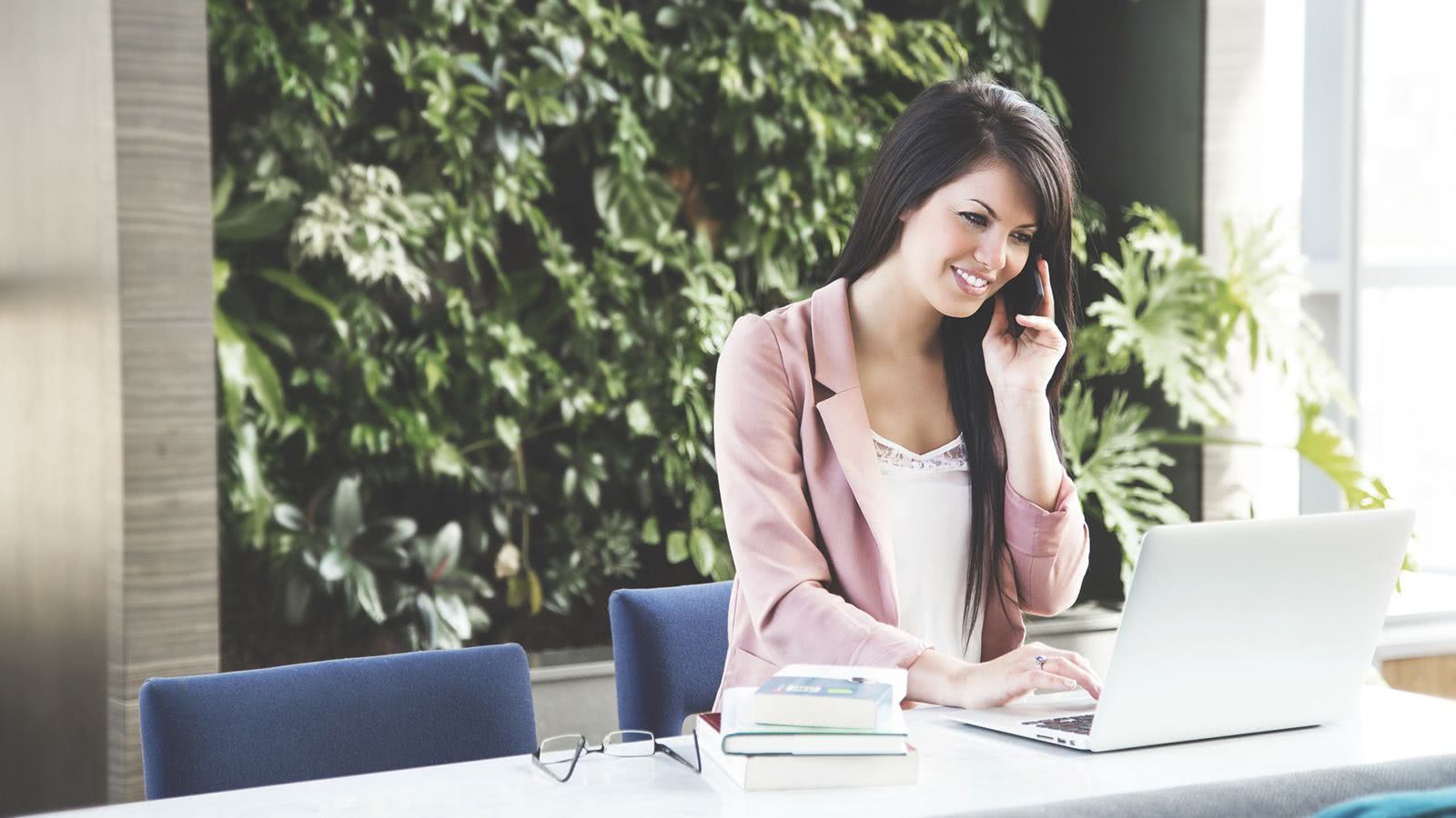 Department manager on phone and laptop hopeful of discovering her staff is on the same page on how they each view what trust actually means